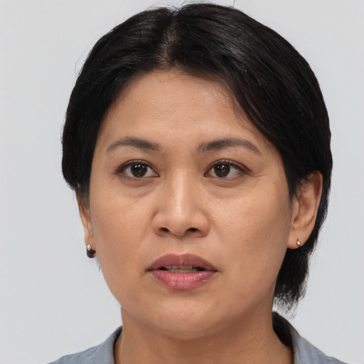 Joyful asian adult female with medium  black hair and brown eyes