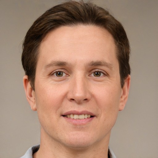 Joyful white adult male with short  brown hair and grey eyes