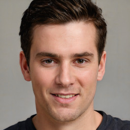 Joyful white young-adult male with short  brown hair and grey eyes