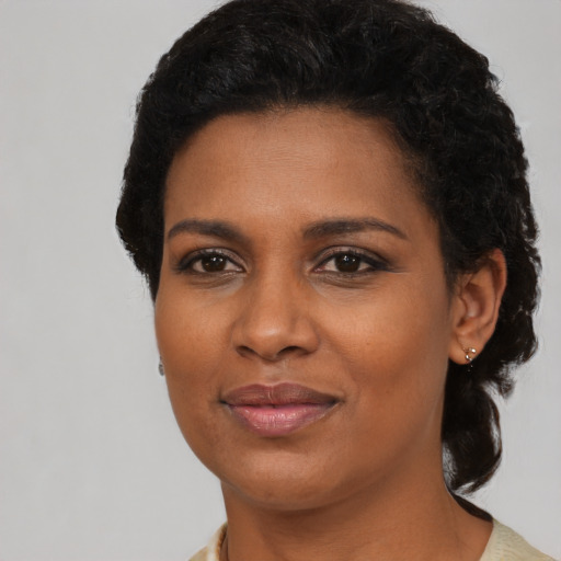Joyful black young-adult female with short  brown hair and brown eyes