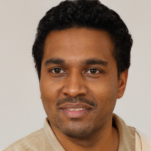 Joyful black young-adult male with short  black hair and brown eyes