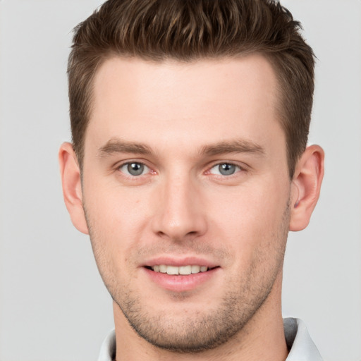 Joyful white young-adult male with short  brown hair and grey eyes