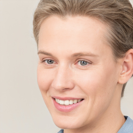 Joyful white young-adult female with short  brown hair and grey eyes