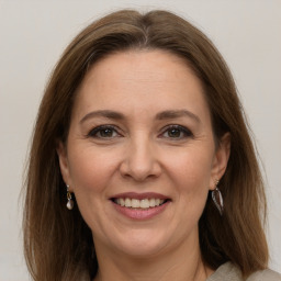 Joyful white adult female with long  brown hair and grey eyes