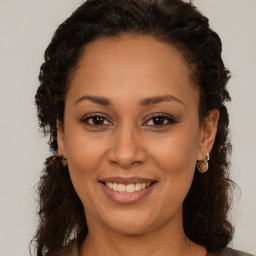 Joyful black adult female with medium  brown hair and brown eyes