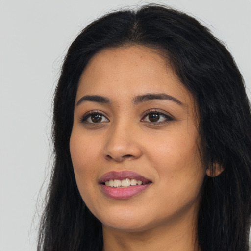 Joyful latino young-adult female with long  black hair and brown eyes