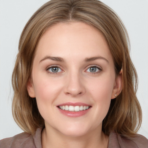 Joyful white young-adult female with medium  brown hair and blue eyes