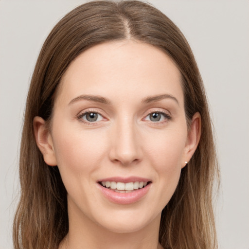 Joyful white young-adult female with long  brown hair and grey eyes