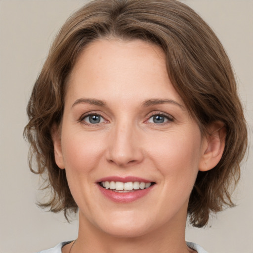 Joyful white young-adult female with medium  brown hair and green eyes