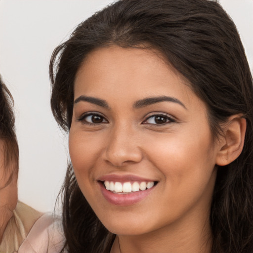 Joyful white young-adult female with long  brown hair and brown eyes