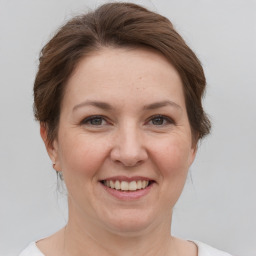 Joyful white adult female with short  brown hair and grey eyes