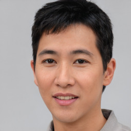 Joyful asian young-adult male with short  brown hair and brown eyes