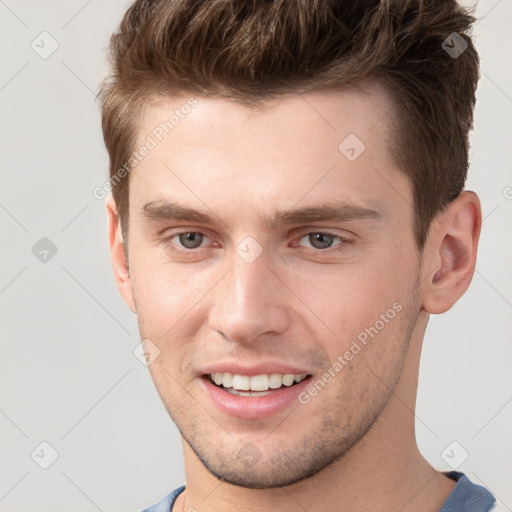 Joyful white young-adult male with short  brown hair and grey eyes