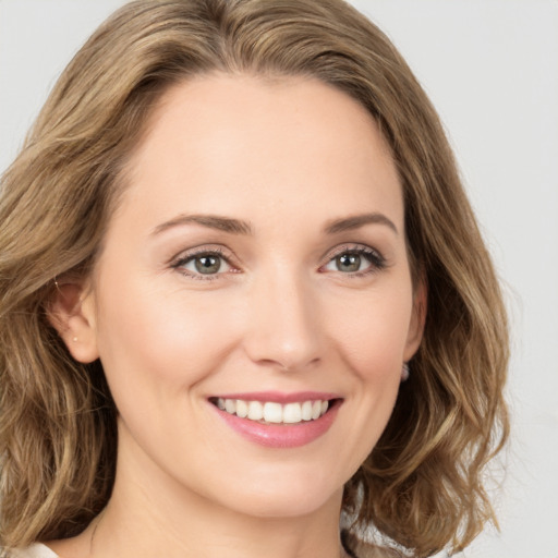 Joyful white young-adult female with long  brown hair and green eyes