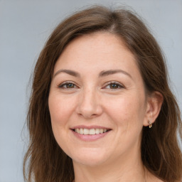 Joyful white adult female with long  brown hair and brown eyes