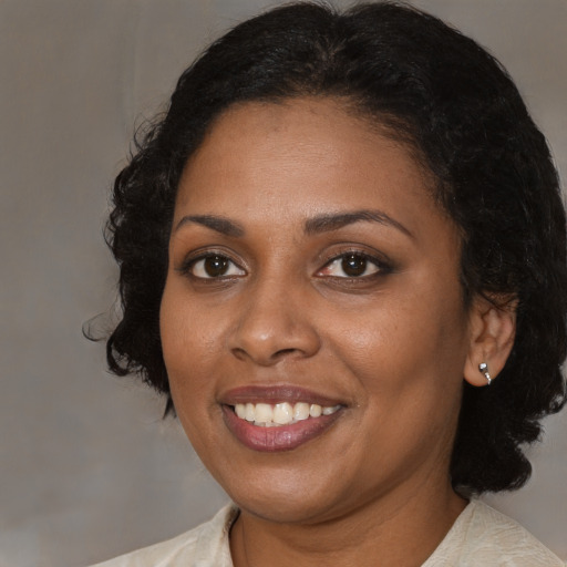 Joyful black adult female with medium  black hair and brown eyes