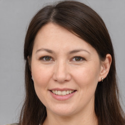 Joyful white adult female with long  brown hair and brown eyes