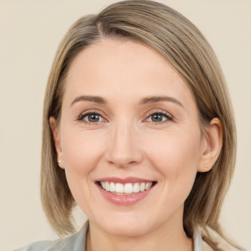 Joyful white young-adult female with medium  brown hair and grey eyes