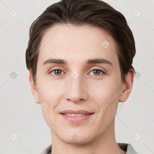 Joyful white young-adult male with short  brown hair and grey eyes