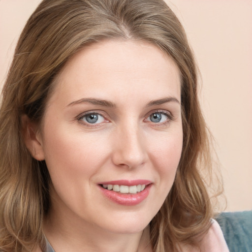 Joyful white young-adult female with long  brown hair and blue eyes