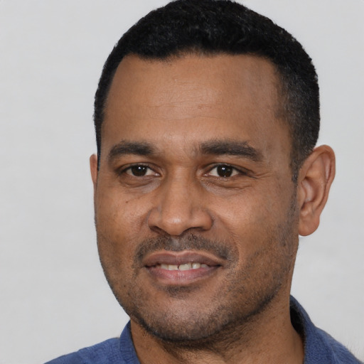 Joyful latino adult male with short  black hair and brown eyes