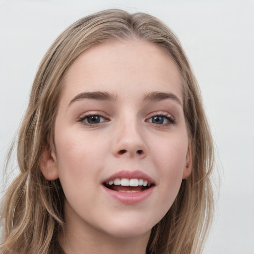 Joyful white child female with long  brown hair and blue eyes