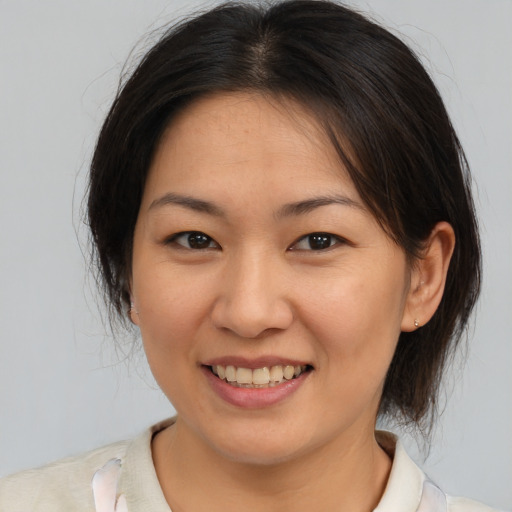Joyful asian young-adult female with medium  brown hair and brown eyes