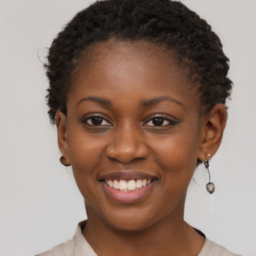 Joyful black young-adult female with short  brown hair and brown eyes