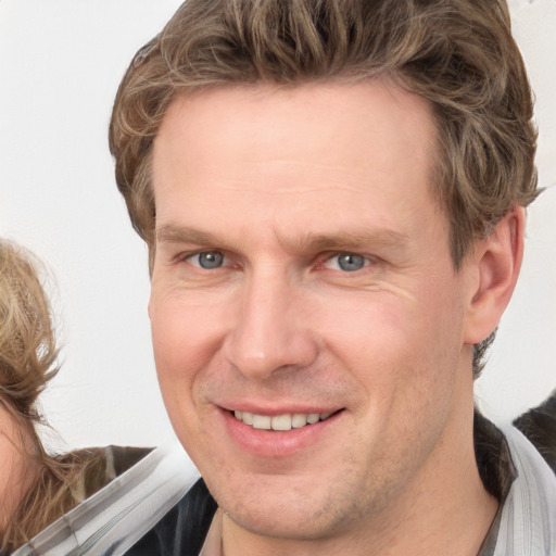 Joyful white adult male with short  brown hair and grey eyes