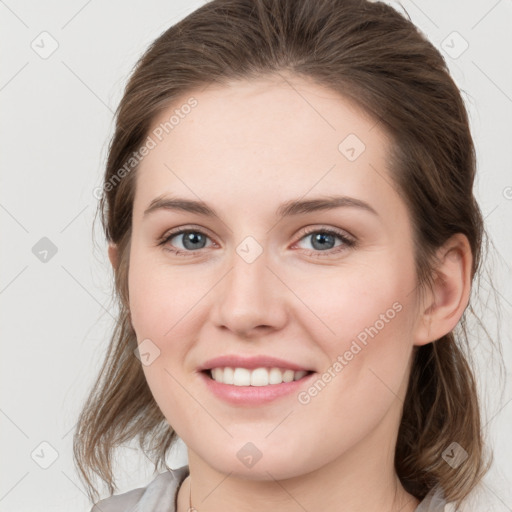 Joyful white young-adult female with medium  brown hair and grey eyes