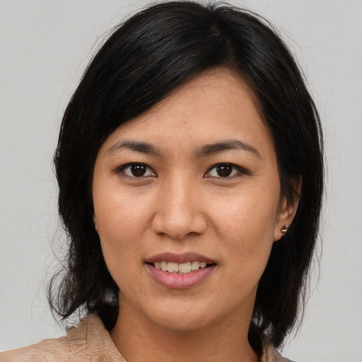 Joyful asian adult female with medium  brown hair and brown eyes