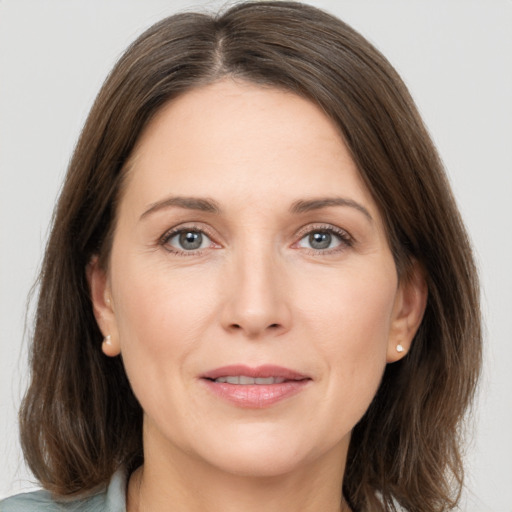 Joyful white adult female with medium  brown hair and grey eyes