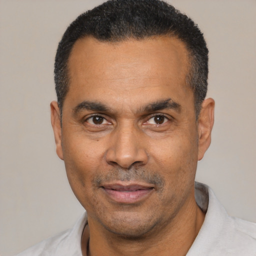 Joyful latino adult male with short  black hair and brown eyes