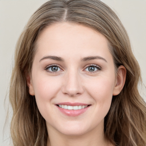 Joyful white young-adult female with long  brown hair and grey eyes