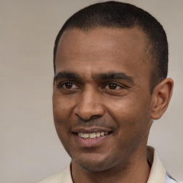 Joyful latino young-adult male with short  brown hair and brown eyes