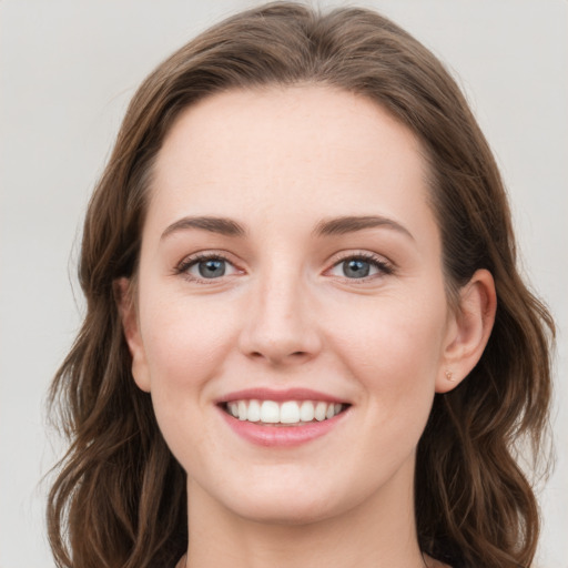 Joyful white young-adult female with long  brown hair and blue eyes