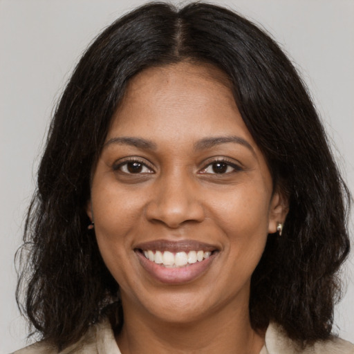 Joyful black young-adult female with medium  brown hair and brown eyes