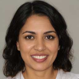 Joyful latino young-adult female with medium  brown hair and brown eyes