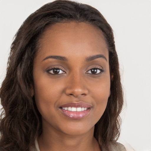 Joyful black young-adult female with long  brown hair and brown eyes