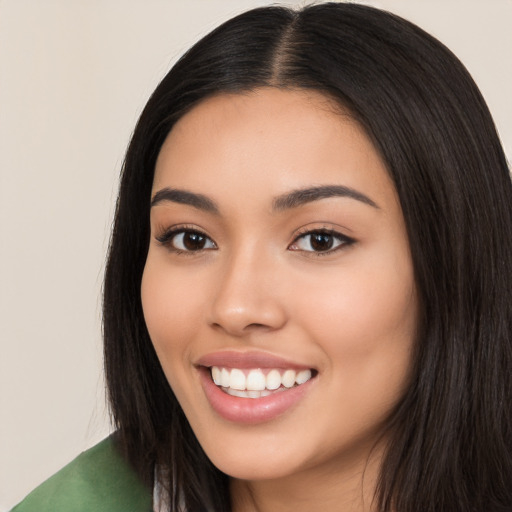 Joyful latino young-adult female with long  black hair and brown eyes