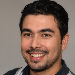 Joyful white young-adult male with short  black hair and brown eyes