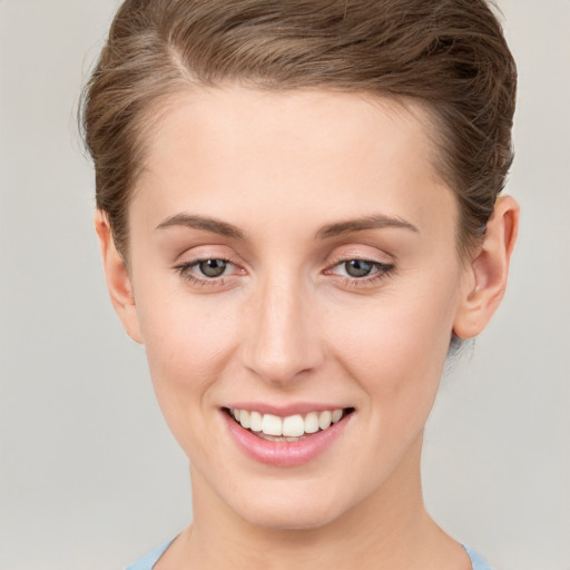 Joyful white young-adult female with short  brown hair and grey eyes