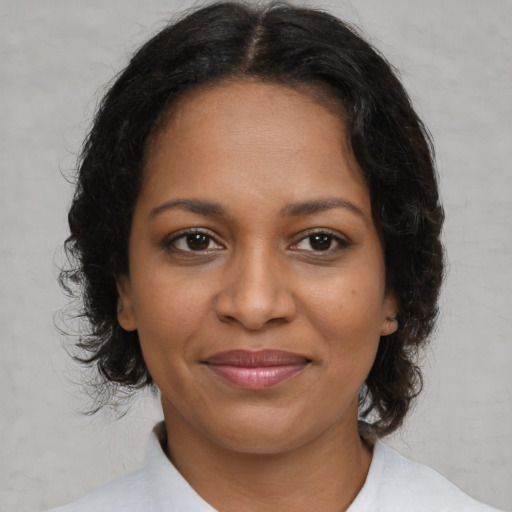 Joyful black adult female with medium  brown hair and brown eyes