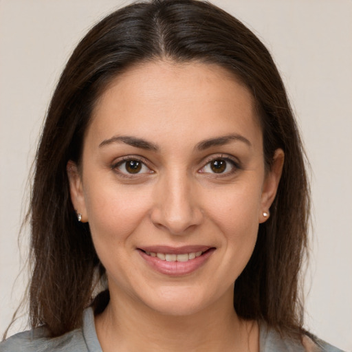 Joyful white young-adult female with long  brown hair and brown eyes