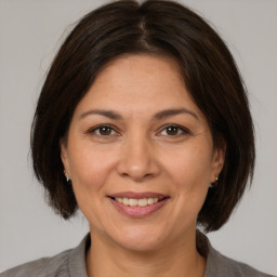 Joyful white adult female with medium  brown hair and brown eyes