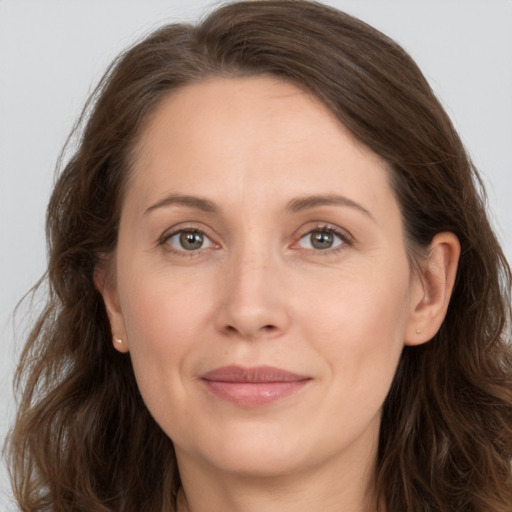 Joyful white adult female with long  brown hair and grey eyes