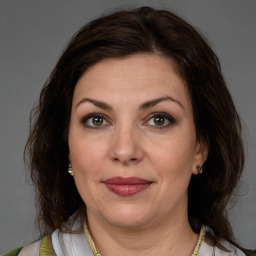 Joyful white adult female with medium  brown hair and green eyes