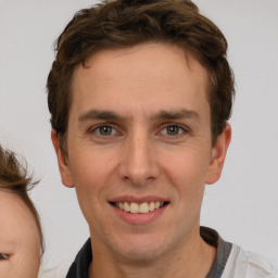 Joyful white adult male with short  brown hair and brown eyes