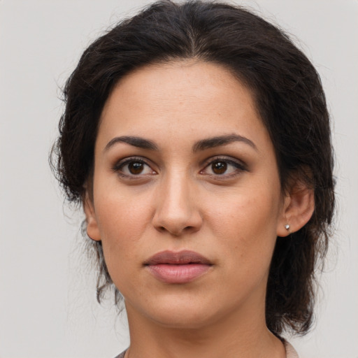 Joyful latino young-adult female with medium  brown hair and brown eyes