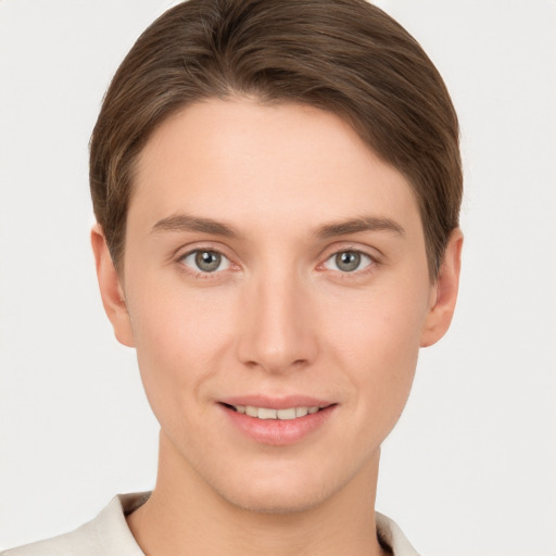 Joyful white young-adult female with short  brown hair and grey eyes